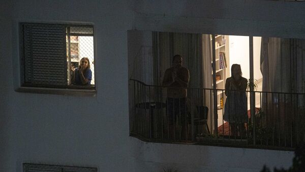 Pessoas saem nas janelas e sacadas de edifícios no bairro de Perdizes, em São Paulo, para realizar uma salva de palmas em homenagem aos médicos que estão atuando nos cuidados aos pacientes que contraíram o novo coronavírus - Sputnik Brasil