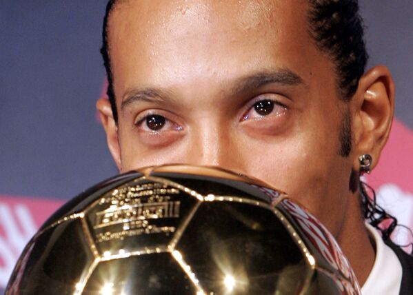 Jogador de futebol brasileiro Ronaldinho Gaúcho beija prêmio de melhor jogador de futebol do ano na Europa, em 2005 - Sputnik Brasil