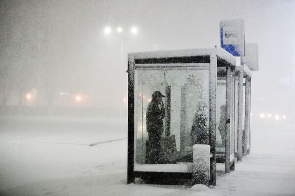 Pessoas esperando transporte público em ponto de ônibus durante nevasca que atinge a cidade russa de Podolsk, na região de Moscou - Sputnik Brasil
