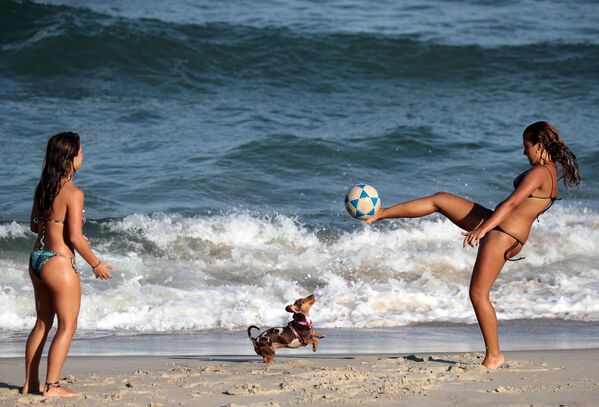 Duas moças brincam com uma bola na praia do Diabo, na cidade do Rio de Janeiro, após autoridades anunciarem medidas para conter o avanço do coronavírus - Sputnik Brasil