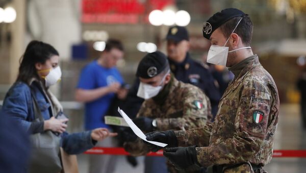 Soldados com máscaras conferem documentos de passageiros antes de embarque em estação de trem de Milão, na Itália - Sputnik Brasil