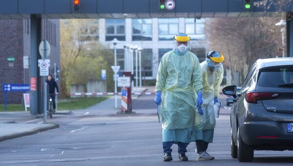 Funcionários com trajes de proteção contra o coronavírus diante de um hospital na Alemanha. - Sputnik Brasil
