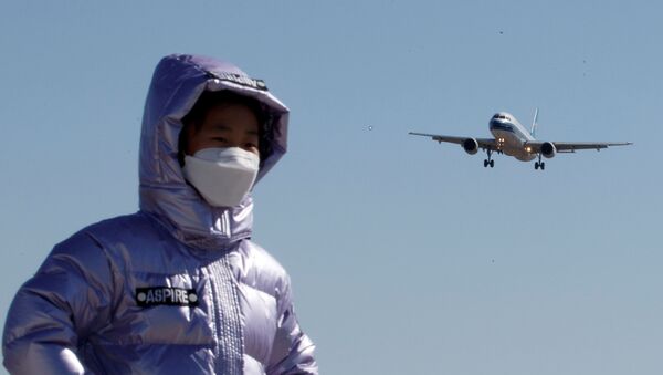 Estudante usando máscara protetora posa para foto perto do Aeroporto Internacional de Pequim, na China, 13 de março de 2020   - Sputnik Brasil