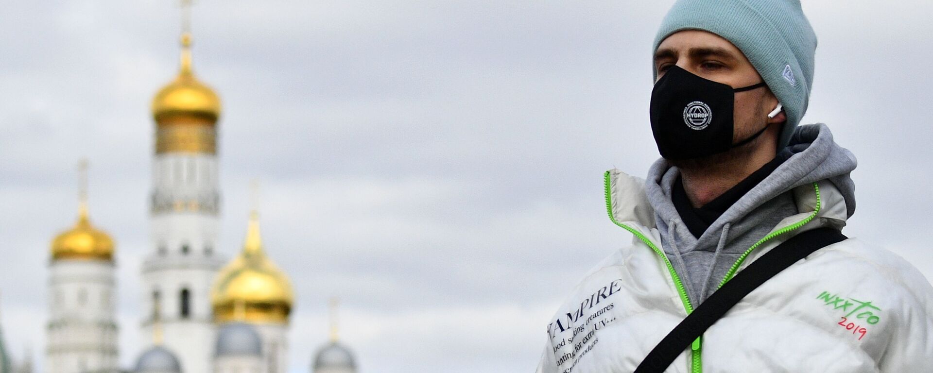 Jovem usando máscara protetora próximo a igreja ortodoxa em Moscou, 21 de março de 2020      - Sputnik Brasil, 1920, 07.01.2023