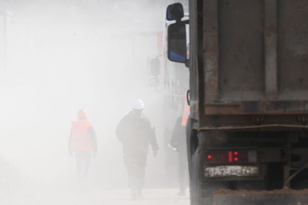 Trabalhadores e nuvem de poeira levantada por caminhões no canteiro de obras do novo hospital de infectologia - Sputnik Brasil