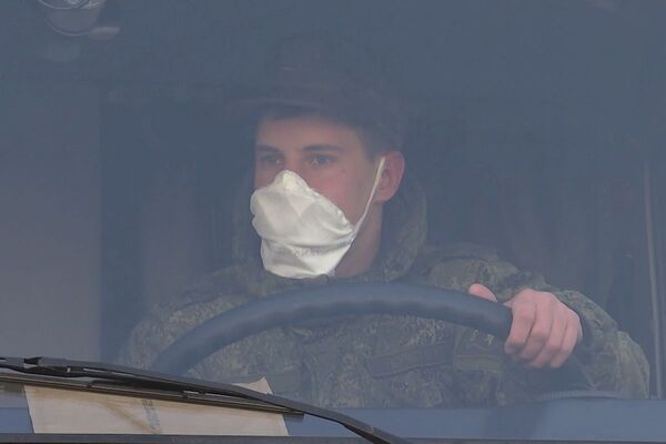 Motorista com máscara de proteção em caminhão de transporte de especialistas russos na Itália - Sputnik Brasil