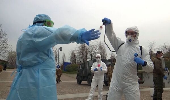Especialistas russos realizam limpeza de traje de proteção antes de entrar em um hospital de Bergamo - Sputnik Brasil