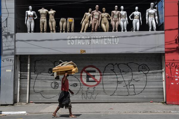 Sem-teto passa por estacionamento fechado e manequins no centro de São Paulo, Brasil, depois que a prefeitura decretou o fechamento de lojas e comércios como medida preventiva contra a propagação do novo coronavírus, 24 de março de 2020 - Sputnik Brasil