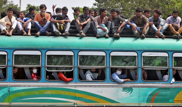 Pessoas viajam em ônibus lotado para retornar às suas casas em meio à pandemia, em Calcutá, Índia, 23 de março de 2020 - Sputnik Brasil