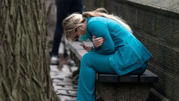 Agente de saúde dos EUA senta em banco no Central Park, em Nova York, 30 de março de 2020 - Sputnik Brasil