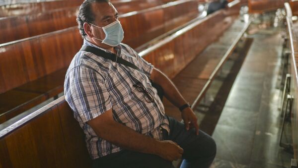 Homem sentado com máscara em igreja no México (foto de arquivo) - Sputnik Brasil