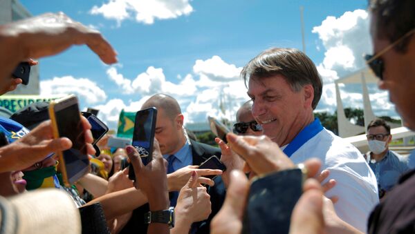 Presidente Jair Bolsonaro cumprimenta apoiadores em manifestação em frente ao Planalto em meio à epidemia do coronavírus - Sputnik Brasil