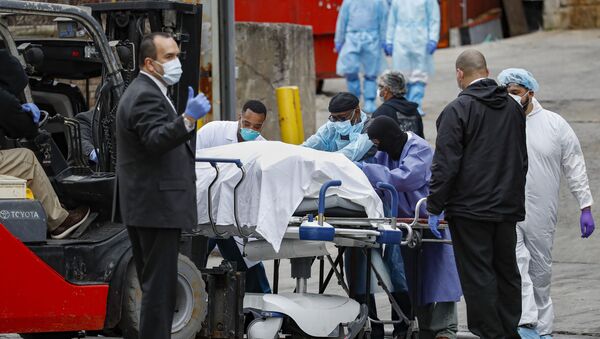 Cadáver de paciente morto pelo coronavírus sendo levado para um caminhão em Nova York, nos EUA - Sputnik Brasil