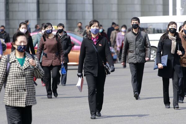 Pedestres com máscaras protetoras em uma rua da capital norte-coreana, Pyongyang - Sputnik Brasil