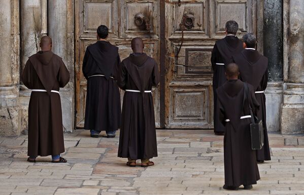 Monges franciscanos rezam em frente às portas fechadas da Igreja do Santo Sepulcro, no bairro cristão da Cidade Velha de Jerusalém, durante as medidas restritivas contra o coronavírus em Israel - Sputnik Brasil