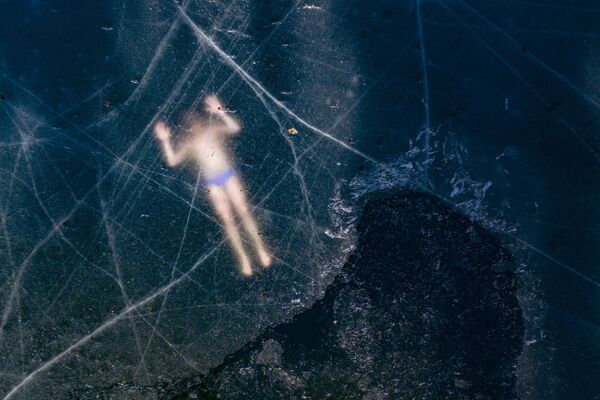 Finlandês Kristian Maki-Jussila, 37, realizando nado livre embaixo de camada de gelo em lago congelado próximo de Vaasa, na Finlândia - Sputnik Brasil