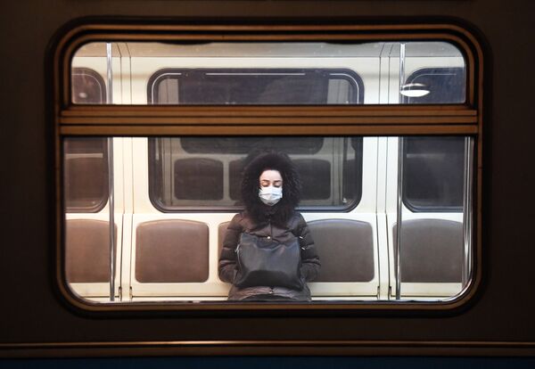 Moça em vagão vazio do metrô moscovita realiza sua viagem usando uma máscara - Sputnik Brasil