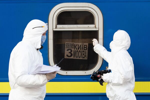 Médicos com trajes de proteção biológica ao lado do trem especial Nº 906/905 Kiev–Moscou–Kiev em terminal ferroviário de Kiev, Ucrânia - Sputnik Brasil