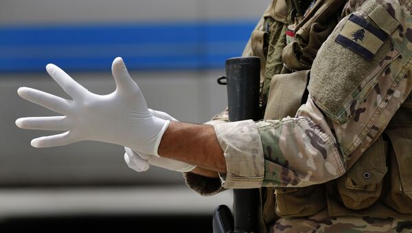Soldado se prepara para fazer inspeção em passageiros em aeroporto, em meio à pandemia de COVID-19 (foto referencial) - Sputnik Brasil