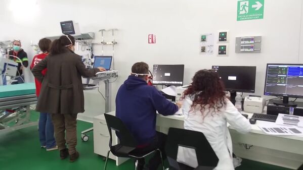 Equipe de funcionários do hospital de campanha de Bergamo em frente a computadores, enquanto unidade hospitalar se prepara para atender pacientes com coronavírus - Sputnik Brasil