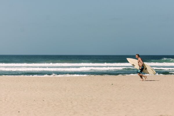 Homem surfa em praia de Dubai em meio à pandemia do coronavírus - Sputnik Brasil