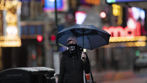 Mulher caminha com máscara sob forte chuva em Nova York, nos Estados Unidos - Sputnik Brasil