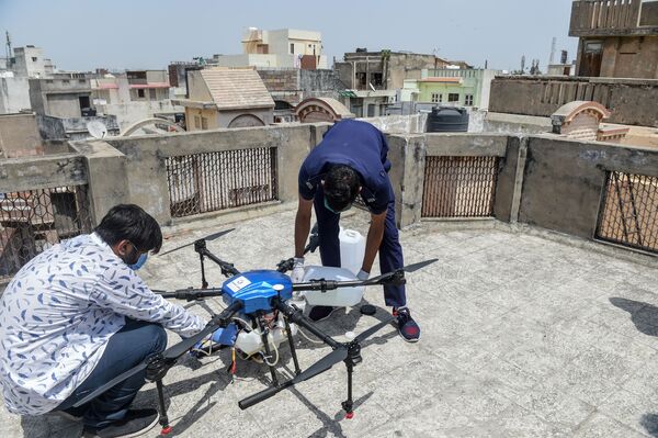 Bombeiro e equipe de operadores em volta de drone na Índia - Sputnik Brasil