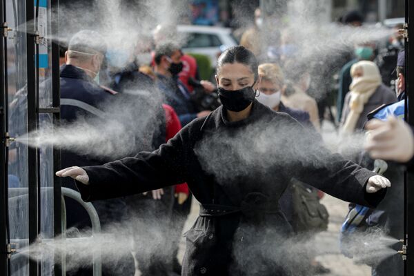 Pessoas são desinfetadas antes de entrar em um mercado em Tirana, na Albânia - Sputnik Brasil