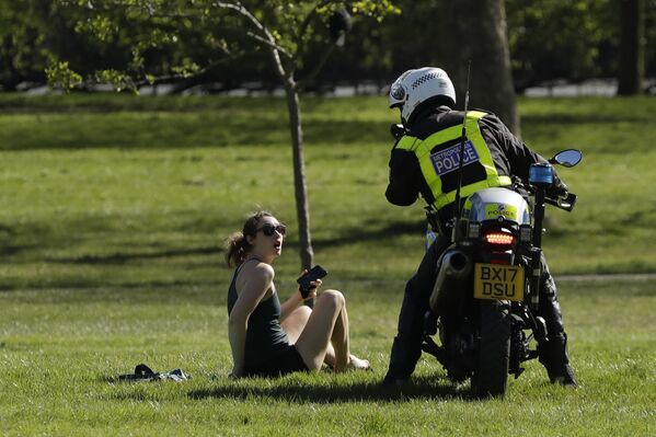 Policial pede a uma visitante para sair do parque devido a medidas restritivas durante a epidemia do novo coronavírus em Londres - Sputnik Brasil