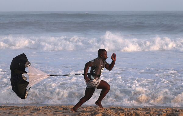 Um homem faz exercícios na praia Recreio dos Bandeirantes em meio ao coronavírus no Rio de Janeiro - Sputnik Brasil