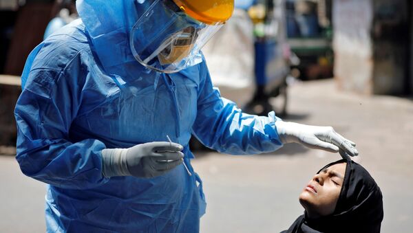 Médico usando equipamento de proteção faz teste de coronavírus a uma mulher em Ahmedabad, Índia - Sputnik Brasil