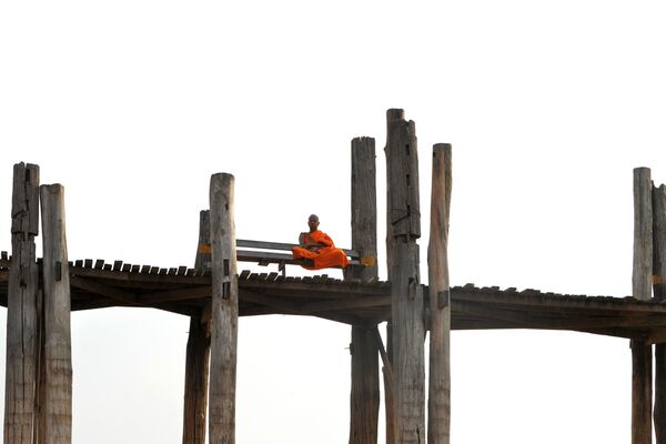 Um monge sentado na ponte de U Bein em Mandalay, no Mianmar - Sputnik Brasil