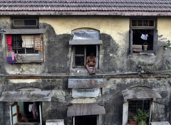 Homem na janela de um apartamento em Mumbai durante o autoisolamento - Sputnik Brasil