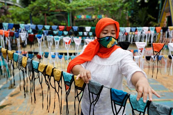 Mulher usa máscara protetora durante a fabricação de máscaras em Jakarta, na Indonésia - Sputnik Brasil