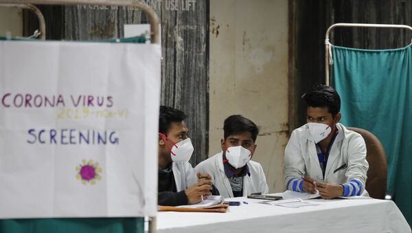 Médicos indianos aguardam em área de diagnóstico de possíveis pacientes da COVID-19 em Delhi, em 13 de março de 2020. - Sputnik Brasil