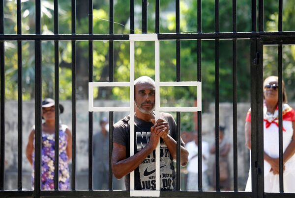 Fiéis ficam em frente a uma igreja fechada ao público no Domingo de Páscoa devido à pandemia em Porto Príncipe, Haiti - Sputnik Brasil