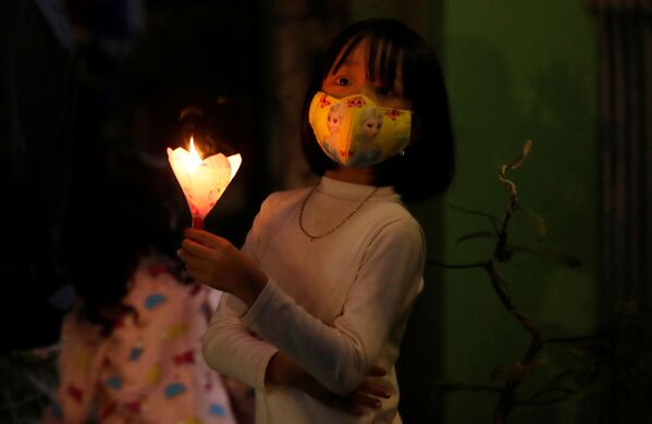Menina usa máscara durante celebração no Domingo de Páscoa em sua casa na província vietnamita de Vinh Phuc - Sputnik Brasil