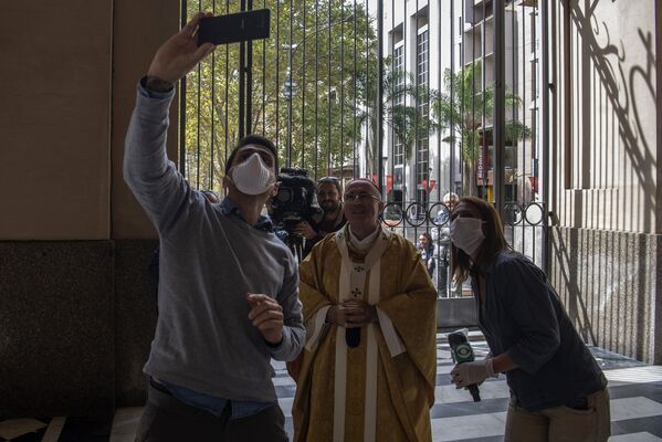 Jornalistas tiram fotos com o cardial uruguaio Daniel Sturla depois da missa de Páscoa em uma igreja vazia - Sputnik Brasil