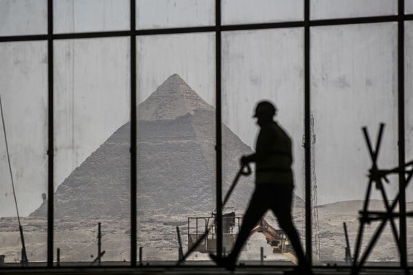 Homem passa diante de janela com vista para pirâmide no Egito - Sputnik Brasil