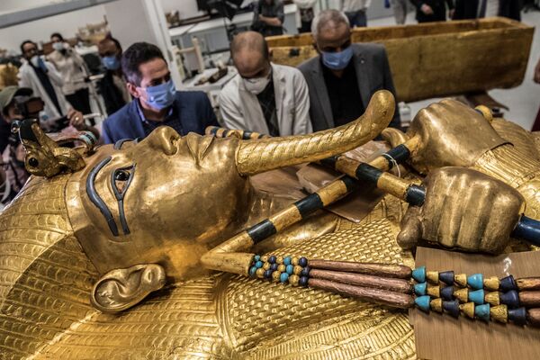 Imagem retrata homens diante de sarcófago dourado do faraó Tutancâmon - Sputnik Brasil