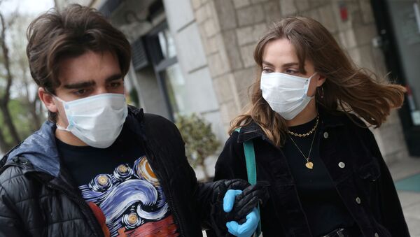 Dois jovens caminhando com máscaras em meio ao surto do coronavírus em Madri, Espanha - Sputnik Brasil