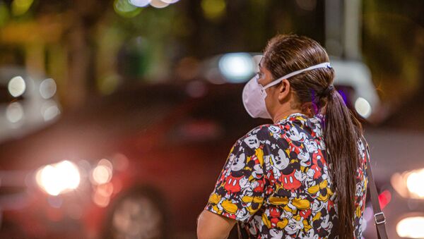 Mulher caminha por rua de Fortaleza, no Ceará, com máscara para se proteger do novo coronavírus - Sputnik Brasil