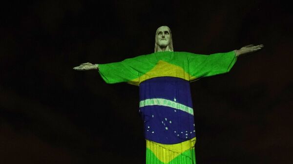 Estátua do Cristo Redentor iluminada com a bandeira do Brasil durante a pandemia de COVID-19. Rio de Janeiro, 12 de abril de 2020 - Sputnik Brasil