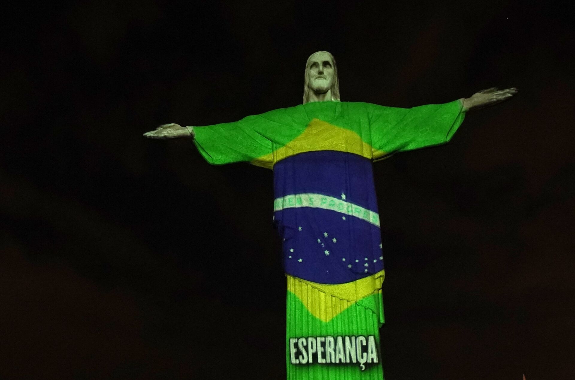 Estátua do Cristo Redentor do Rio de Janeiro é iluminada com a bandeira do Brasil, durante a pandemia do novo coronavírus, no Rio de Janeiro, 12 de abril de 2020 - Sputnik Brasil, 1920, 11.02.2022