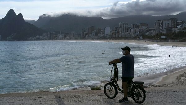 Homem com máscara protetora observa praia do Arpoador durante pandemia do coronavírus no Rio de Janeiro, Brasil, 29 de março de 2020 - Sputnik Brasil