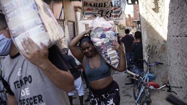 Moradores carregam doações de alimentos durante a pandemia do novo coronavírus da favela do Mandela, no Rio de Janeiro, em 21 de abril de 2020. - Sputnik Brasil