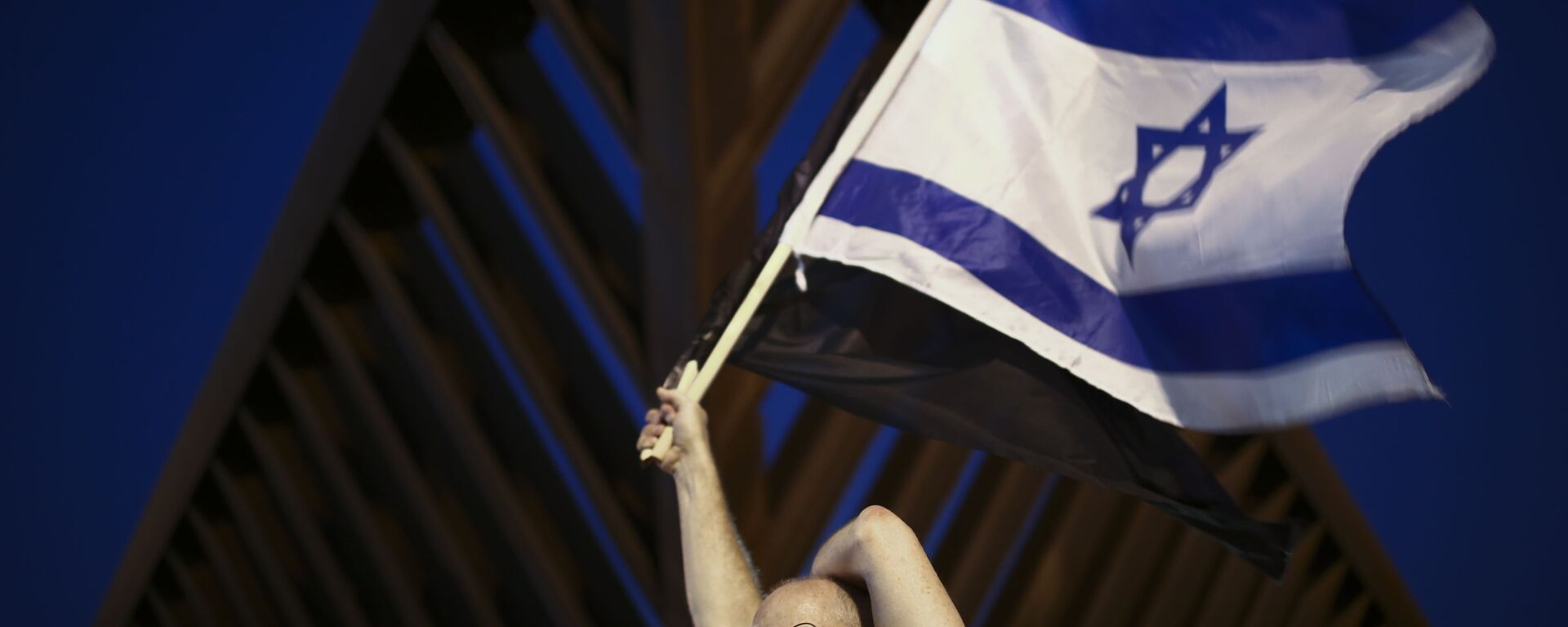 Israelense preocupado com a COVID-19 ostenta uma bandeira do país em Tel Aviv - Sputnik Brasil, 1920, 08.01.2023