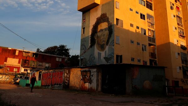 Mulher caminha em frente a grafite de Carlos Tevez nos arredores de Buenos Aires durante pandemia do coronavírus - Sputnik Brasil