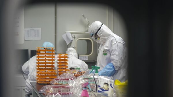 Laboratório na China em que profissionais de saúde realizam testes para identificar pacientes com coronavírus - Sputnik Brasil