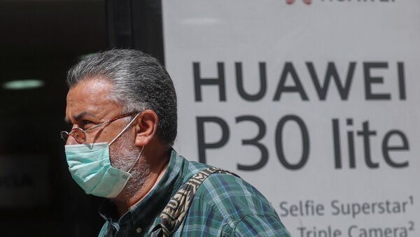 Homem com máscara protetora devido à COVID-19 passando por loja da Huawei - Sputnik Brasil